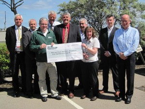 David Cameron (front left in green) of Macmillan Cancer Support accepts a donation check from representatives of the IADC North Sea Chapter: (from left) John Skeggs, Odfjell Drilling; Gary Holman, Archer; Jens Hoffmark, IADC; Glenn White, Rowan Drilling and NSC chairman; Dusty Miller, Diamond Offshore; Edit McLeod, NSC staff; Rob O&rsquo;Neill, Workstrings International; and Martin Ellins, KCA DEUTAG.
